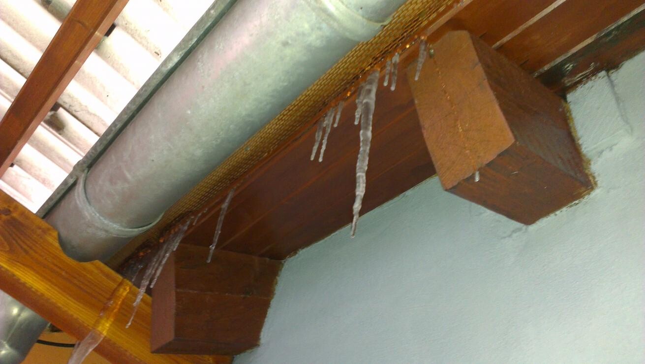 Interior showing visible wooden beam, metal ventilation duct and icicles on the beam.