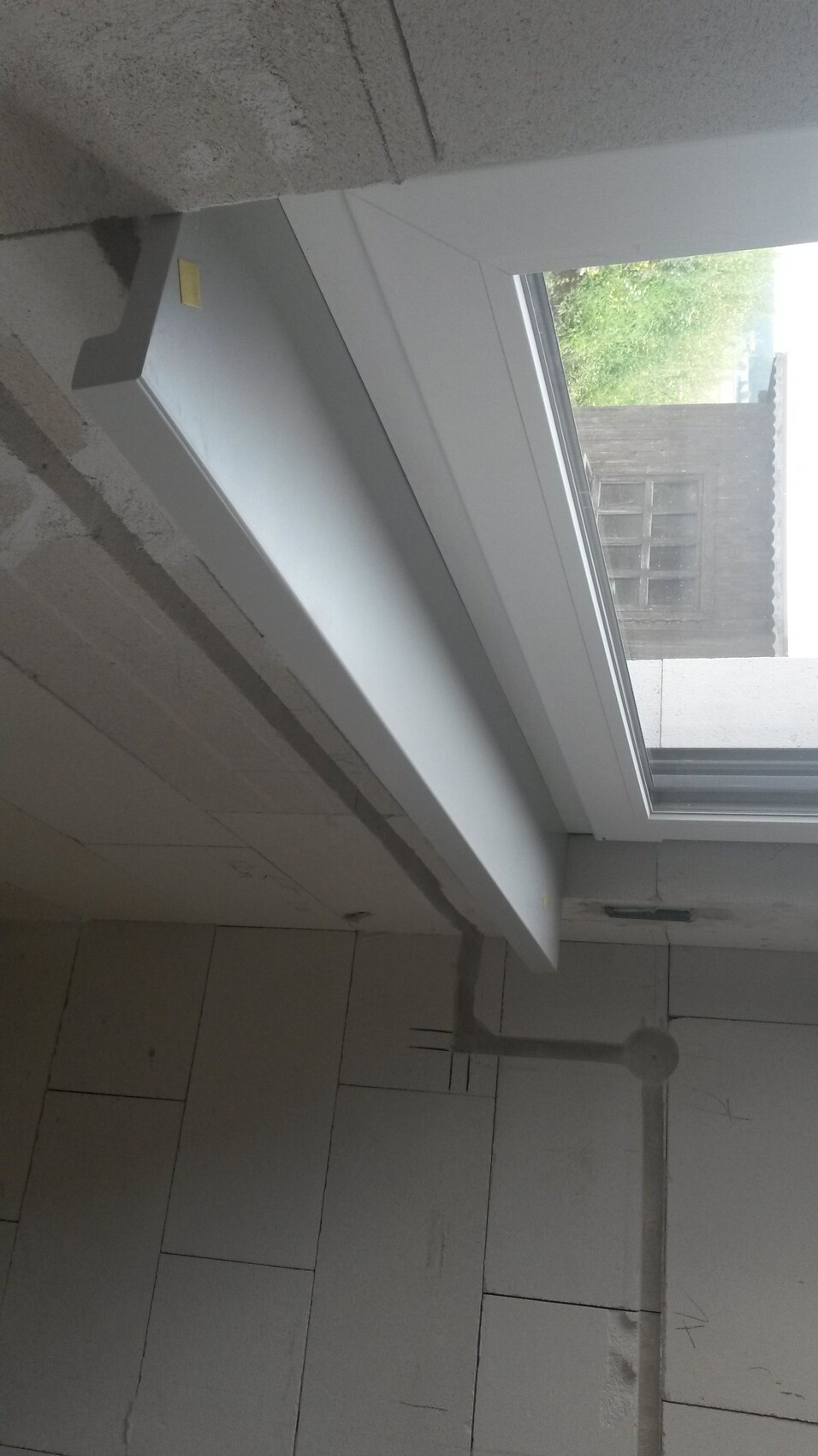 Innenansicht eines renovierten Badezimmers mit Fensterfront und Fliesenboden.