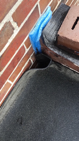 Shell construction façade: brick wall, black substrate and blue sealing tape at corner