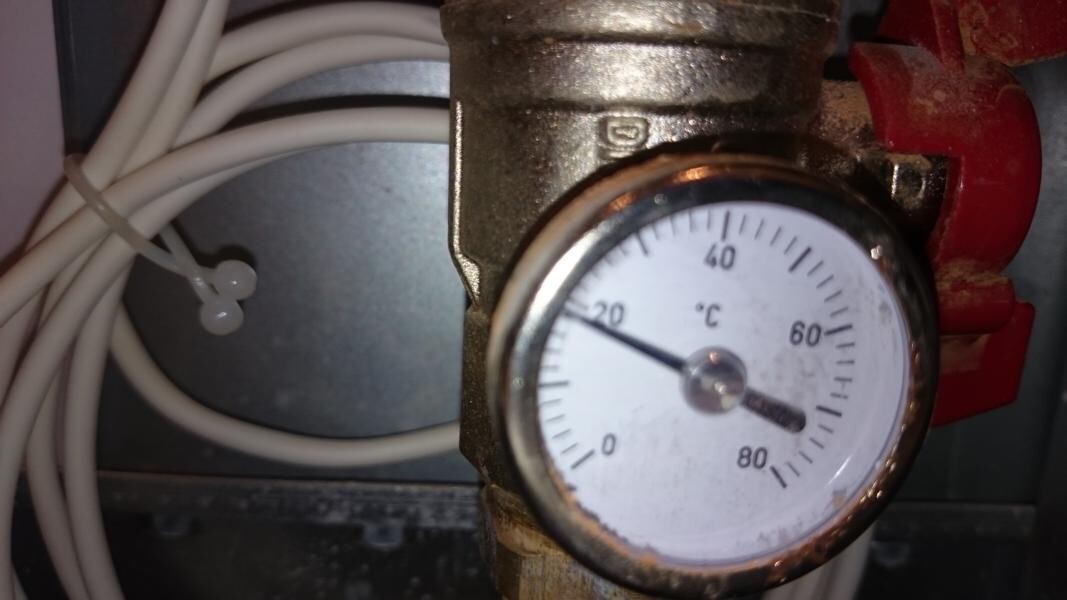 Temperaturmesser an einer Rohrleitung mit Kabeln, Skala 0–80°C, Zeiger bei ca. 20°C.