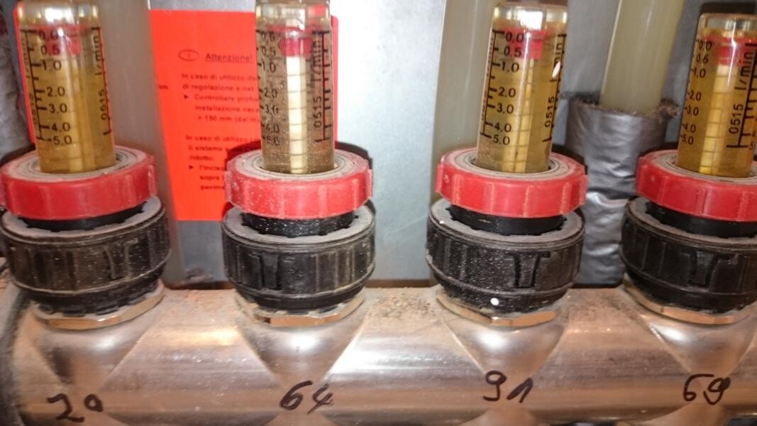 Nahaufnahme eines Ventilblocks mit roten Einstellringen und Messzylindern.