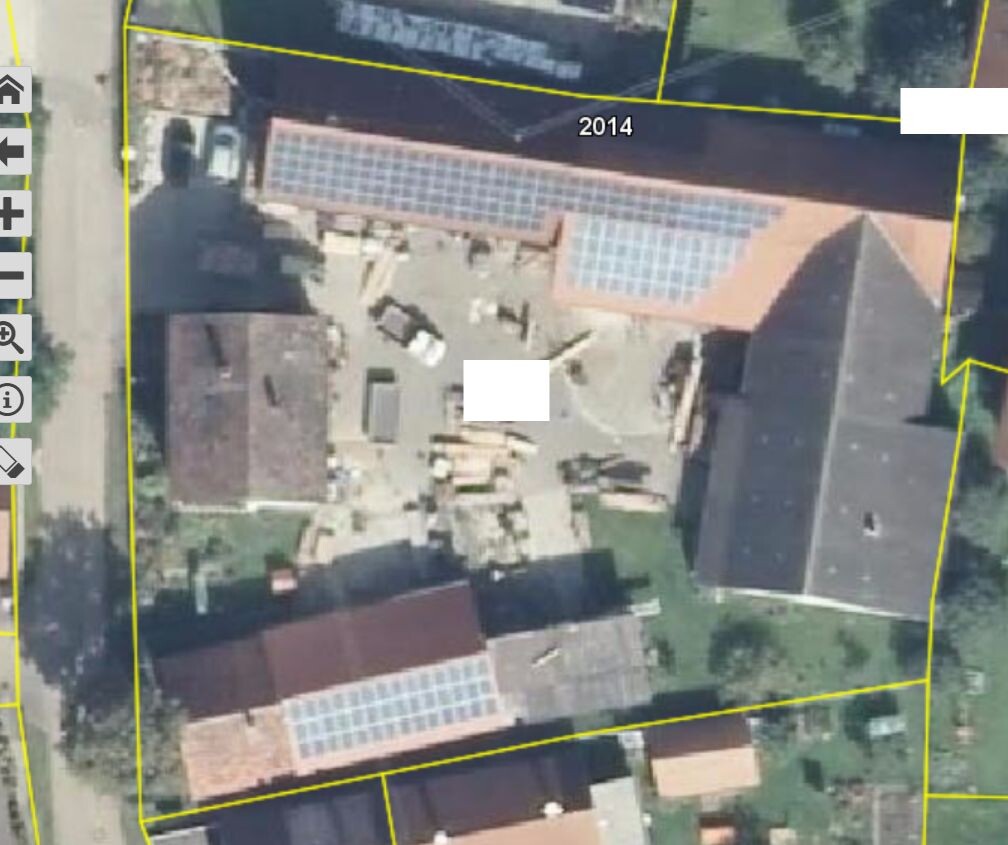 Bird’s-eye view of a property with boundary lines, building area and solar installations