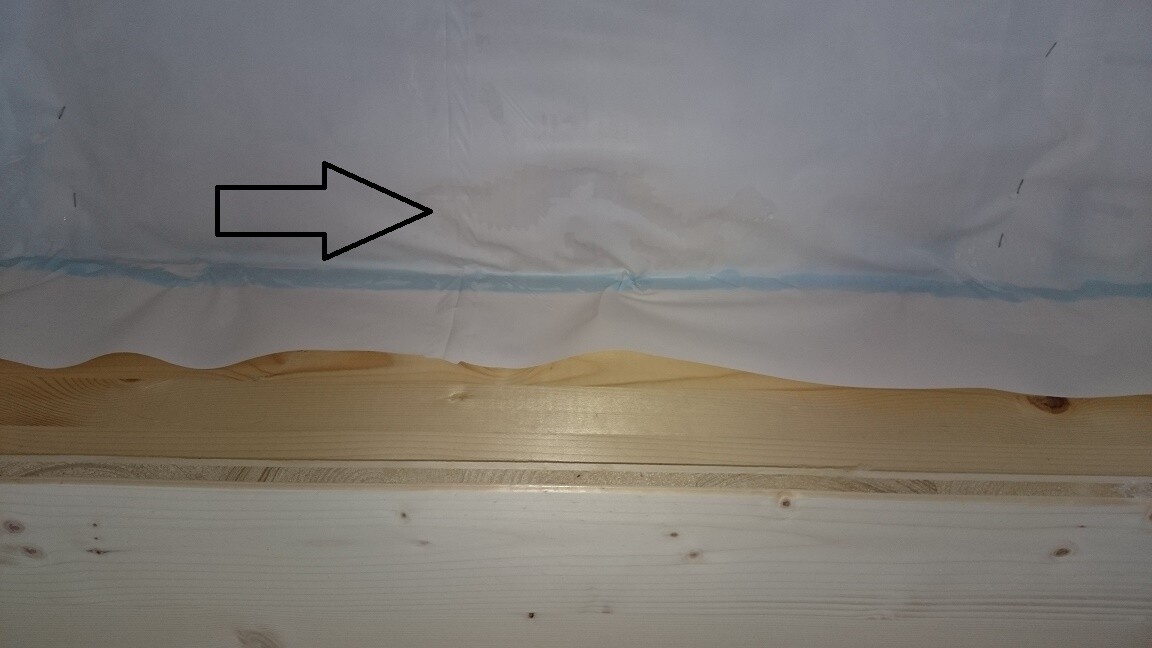 Construction site photo: wooden strip in front of plastic membrane during interior finishing.