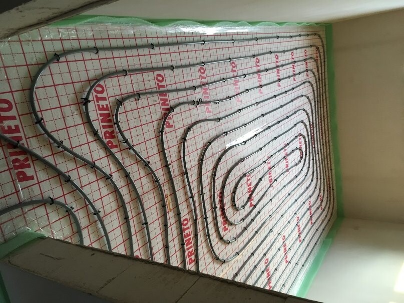 Underfloor heating: spiral-laid pipes in an insulation panel.