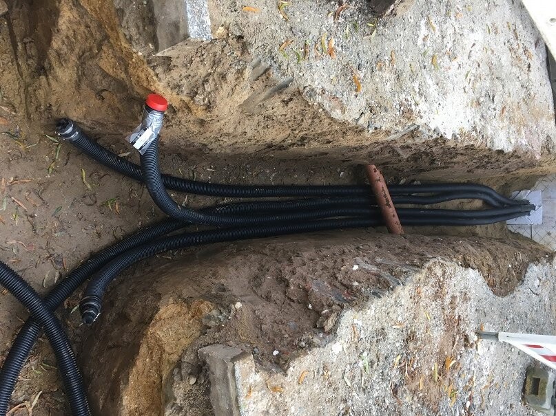 Laid flexible cable ducts in trench for building services and energy supply