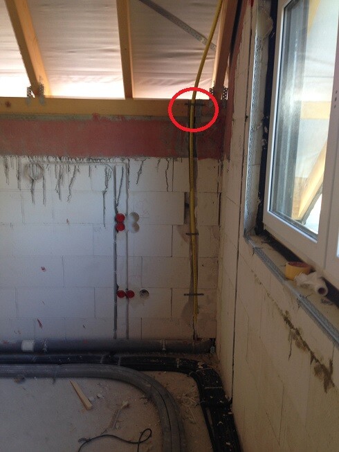 Construction site with exposed building services pipes, shell wall, and window