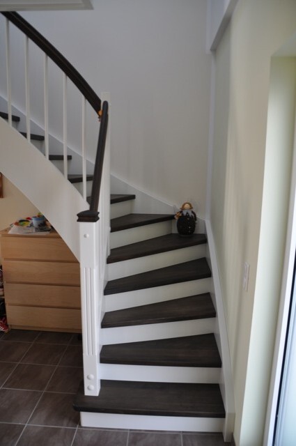 Interior view: staircase with dark wooden treads, white railing; vase on right step.