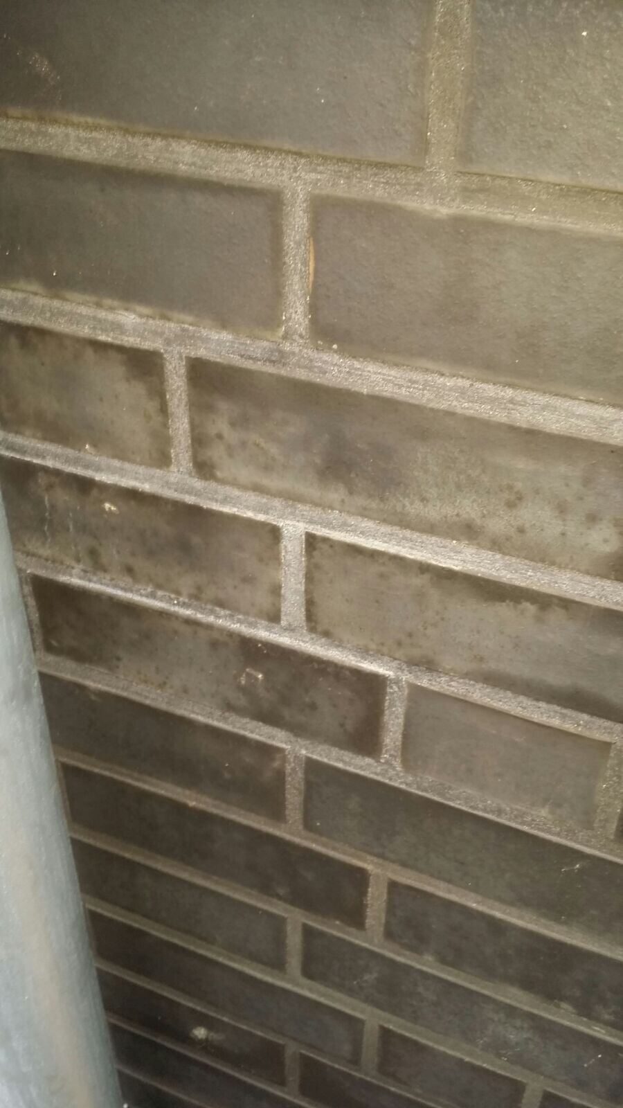Close-up of a dark brick wall with gray mortar joints