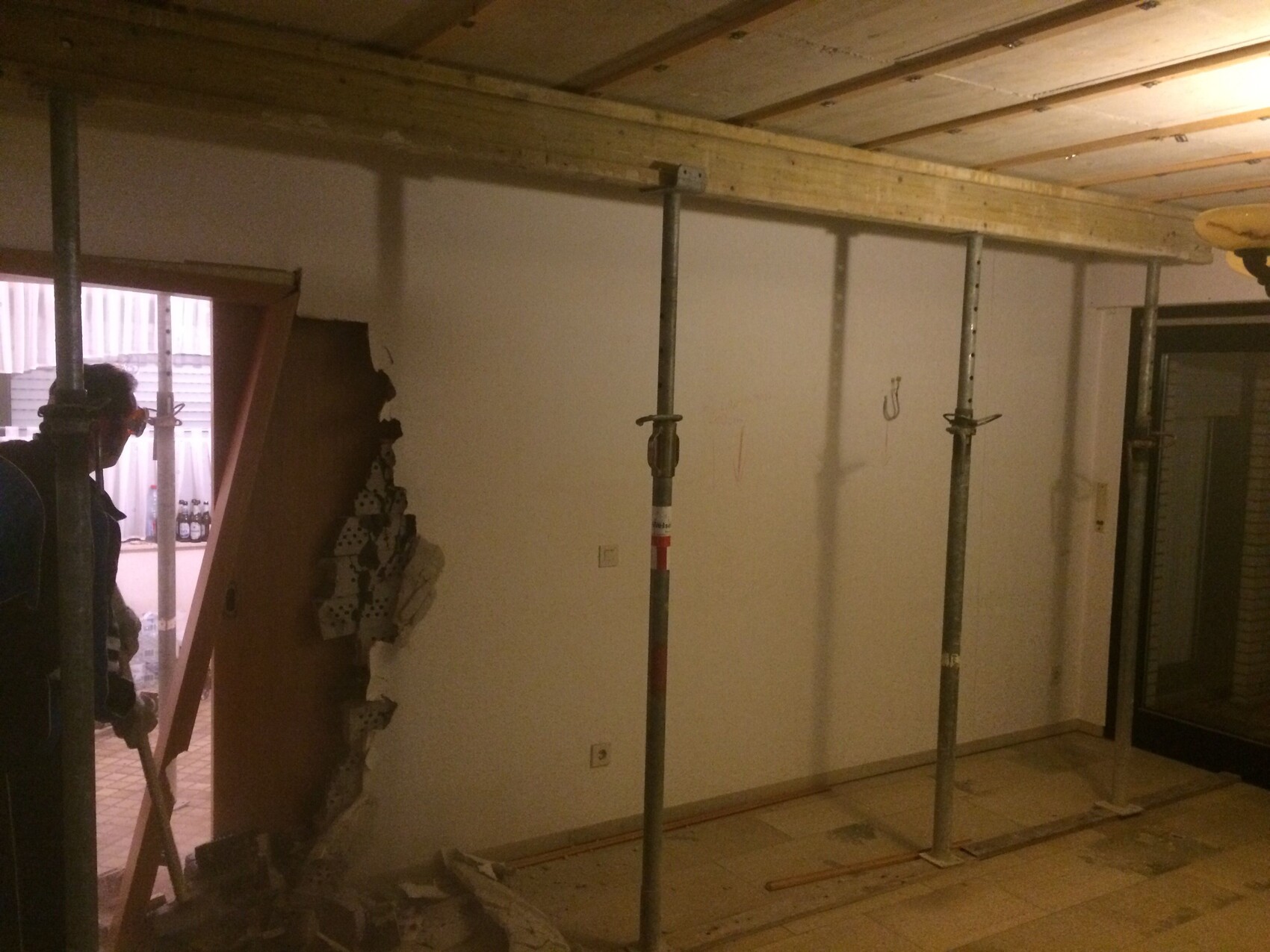 Innenausbau Baustelle mit Stahlstützen, provisorischer Wandöffnung und Bauwerkzeugen