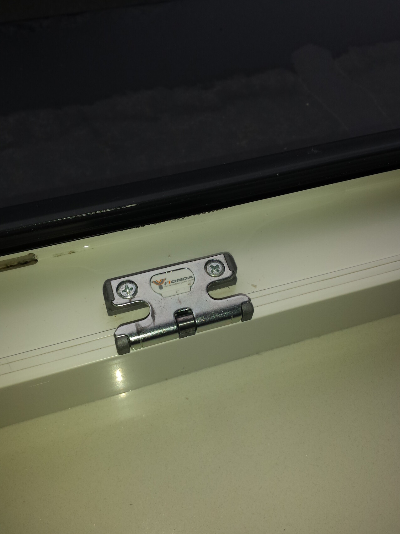 Metal hinges with screw anchoring on a white door frame