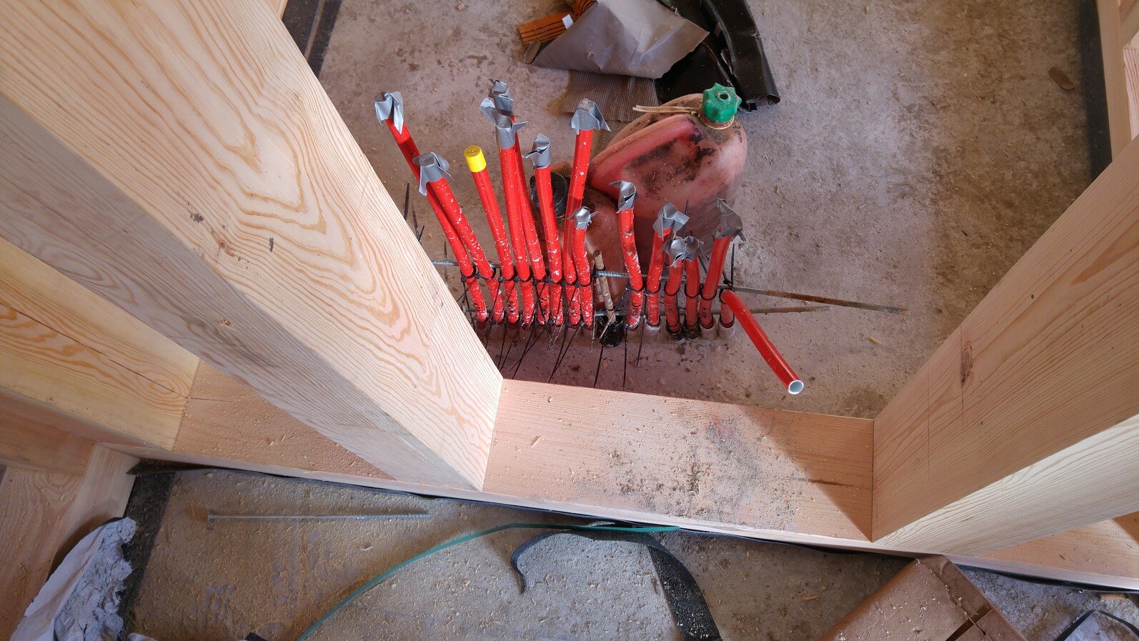 Konstruktionsbaustelle mit roten PEX-Rohrleitungen, Holzrahmen und Baustaub
