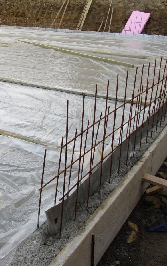 Concrete foundation with steel reinforcement and protective membrane on site
