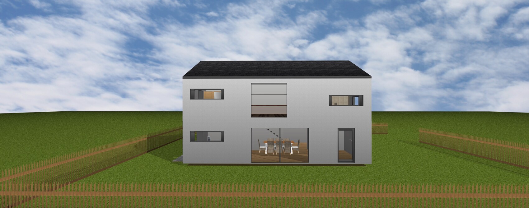 Modern two-story gray house with large glass windows standing on an open meadow and fenced yard.