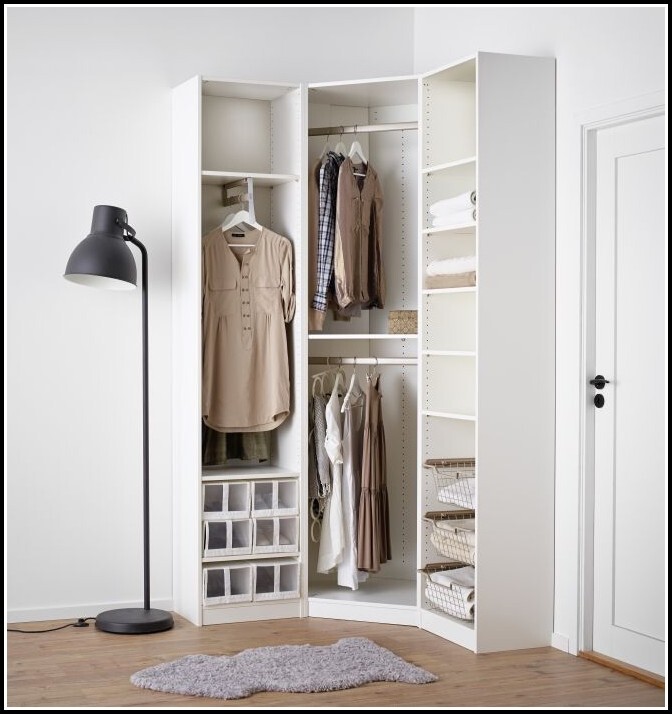 Open wardrobe system with hanging rods, baskets, and drawers in the bedroom.