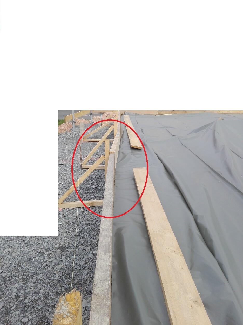 Baustelle mit Holzkonstruktion, Folie und Fundamentbereich im Rohbau