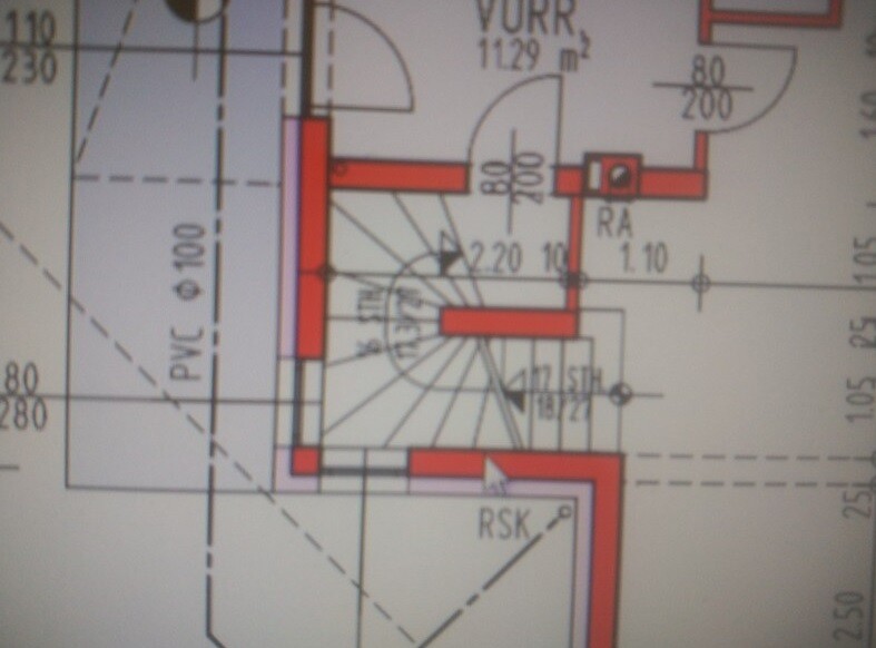 Spiral staircase centered in a building plan, walls, doors, and dimensions marked in red.