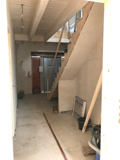 Unfinished interior area of shell construction with staircase