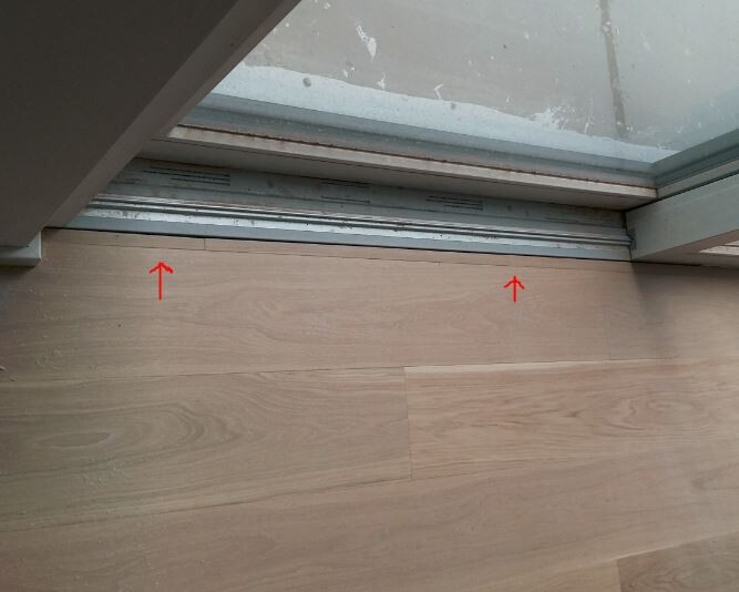 Laminated floor next to glass sliding door with floor track