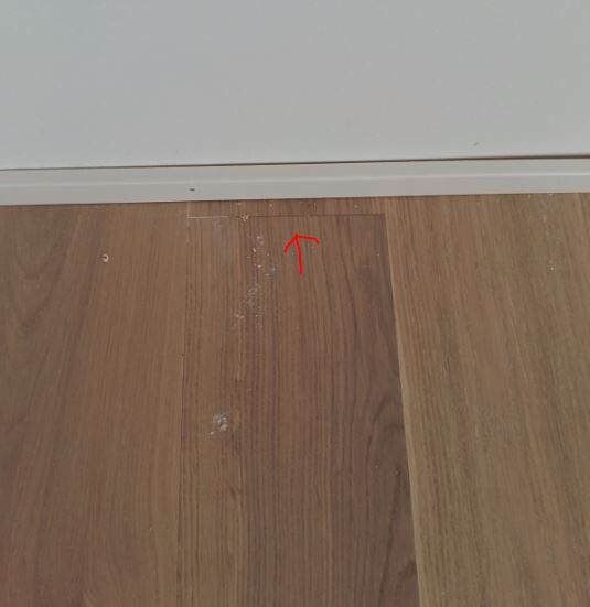 Small gap visible between laminated floor panels near the baseboard.