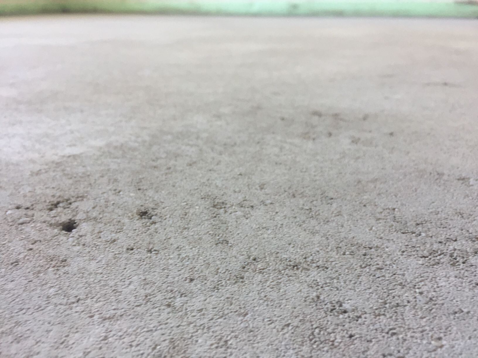 Close-up of a rough concrete floor surface with texture and pores.