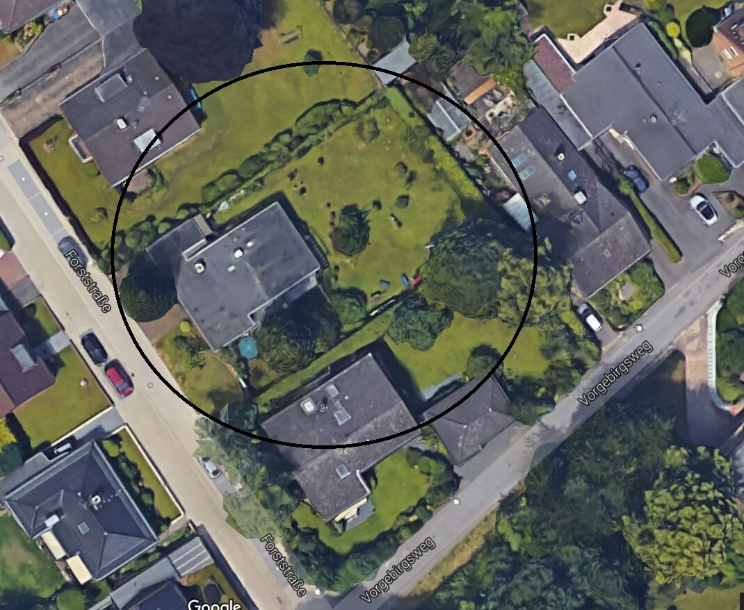 Luftbild einer Wohnimmobilie mit Garten und umliegenden Häusern.