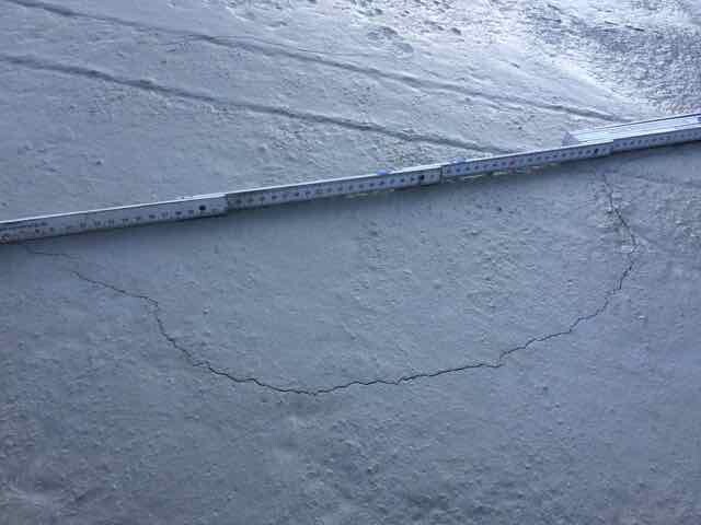 Concrete surface with crack and measuring tape