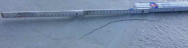 Crack in concrete wall with measuring scale for building inspection