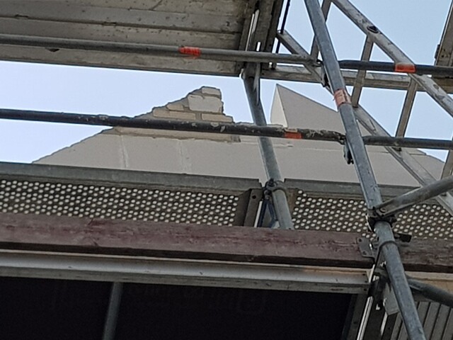 Construction scaffolding in front of unfinished exterior wall of a building at construction site