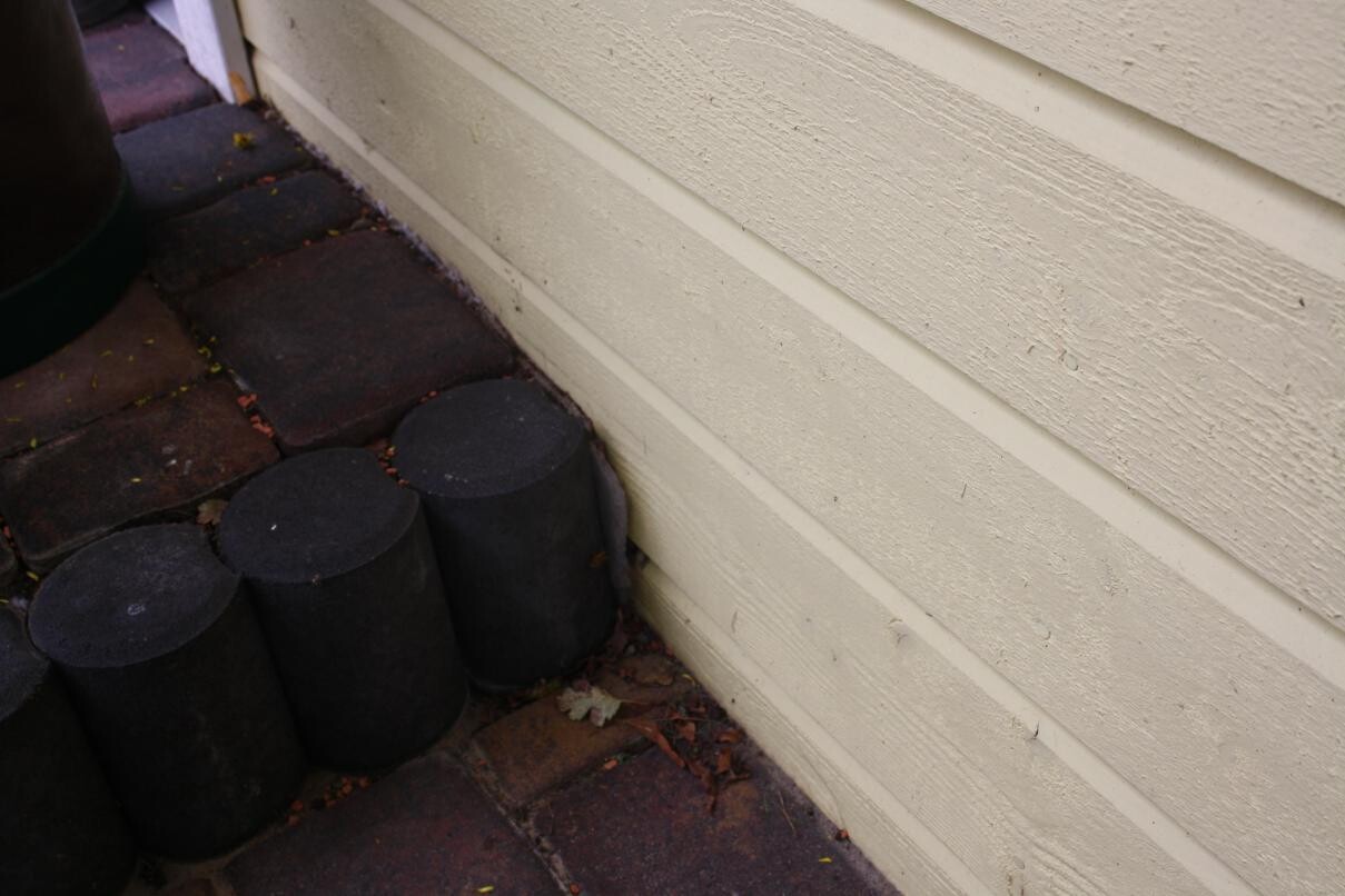 Exterior wall cladding with horizontal panels and visible base plates at the foundation