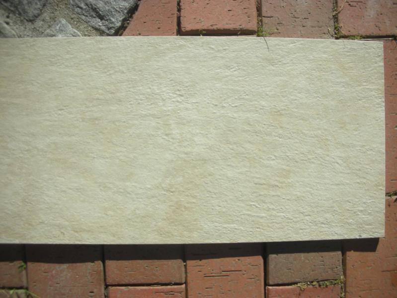 Light stone slab on red paving stone floor outdoors.