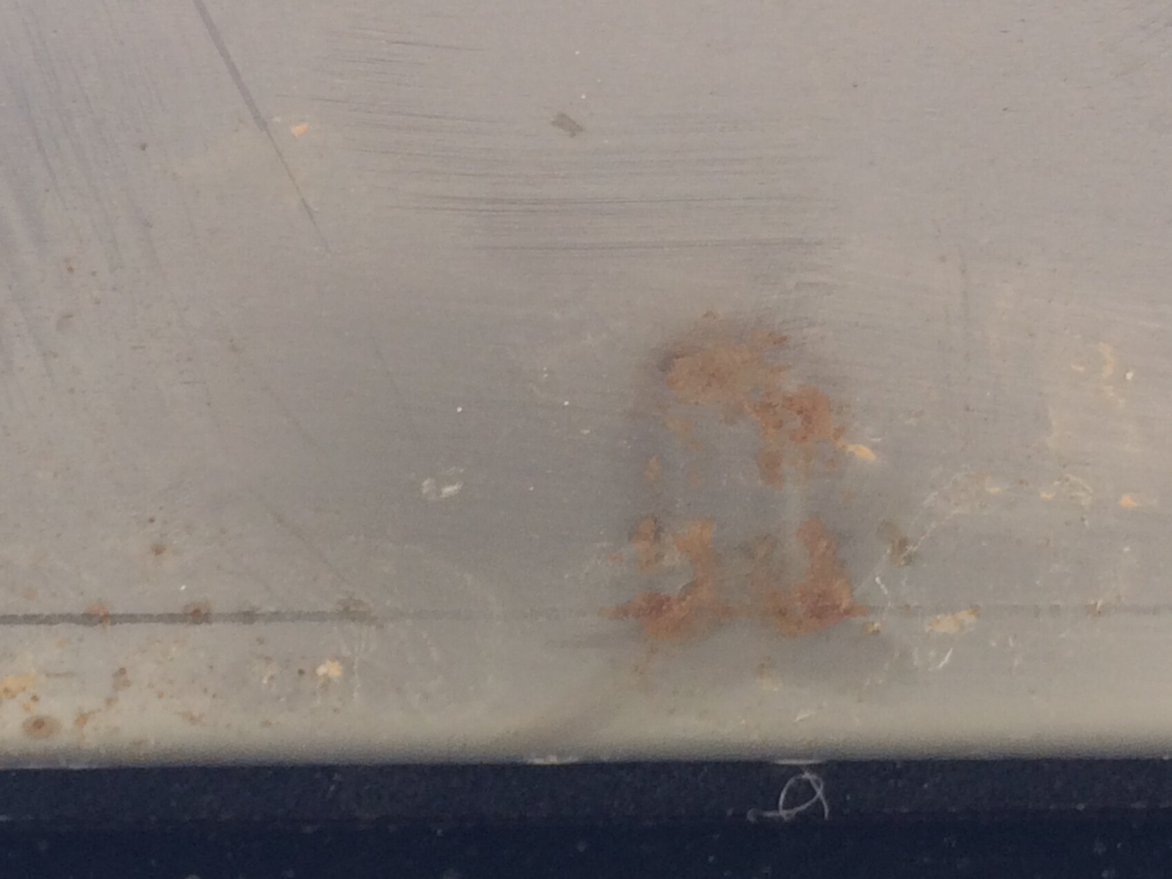 Close-up of rusty metal surface with scratches and stains