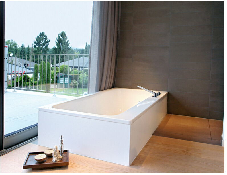 Modern freestanding bathtub next to window with balcony view.