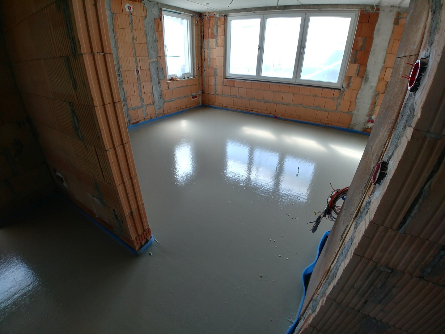 Shell room with glossy epoxy floor, orange brick walls and large windows.