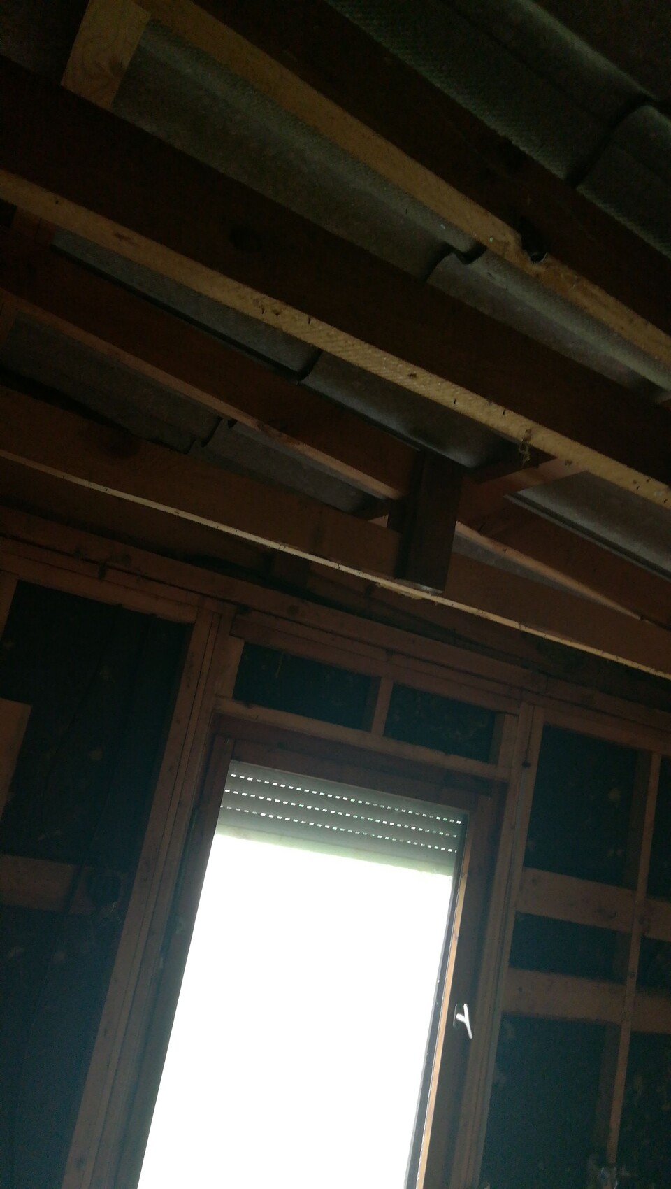 Unprocessed interior with roof beams and window frame in shell construction