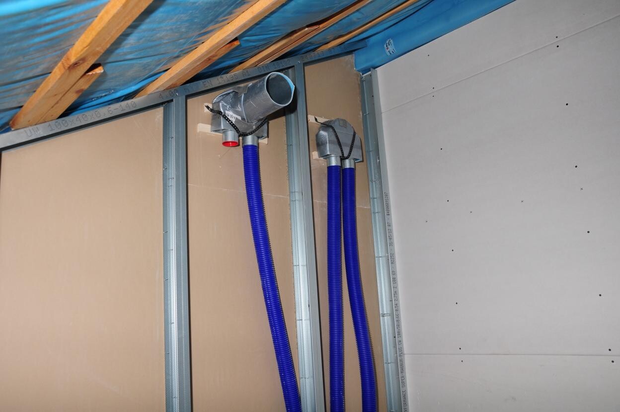 Interior construction: blue flexible electrical cables run through metal stud walls