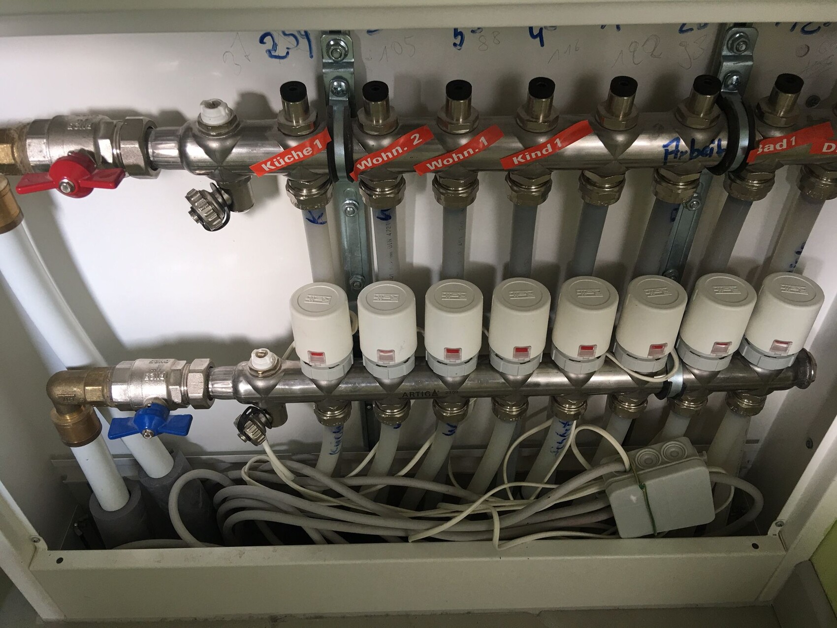 Heating manifold with shut-off valves and thermostatic heads; labels Kitchen 1, Living 2, Child 1