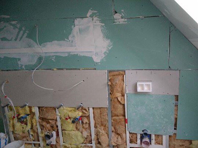 Interior finishing: wall with insulation, drywall, and visible cables