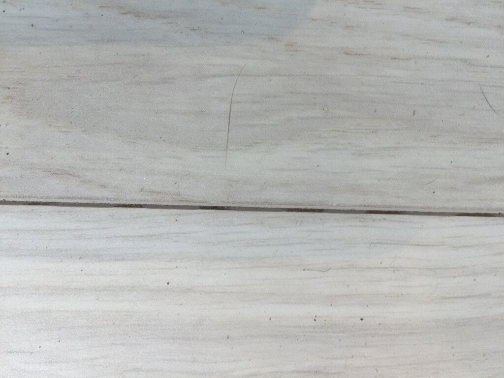 Light wooden floor with wide planks, visible grain and joints