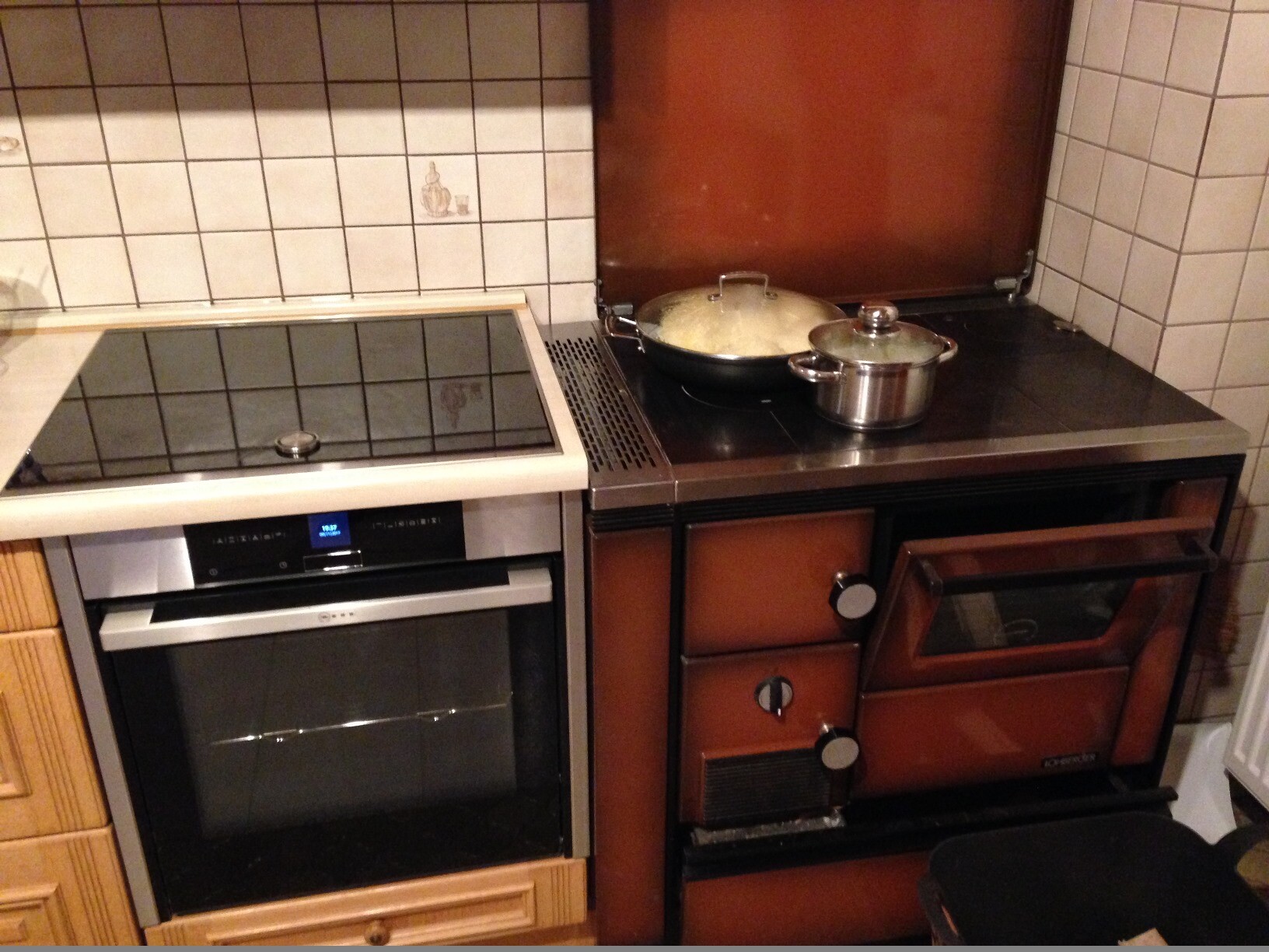 Kitchen with oven on the left and brown vintage stove on the right, pan and pot on the stove