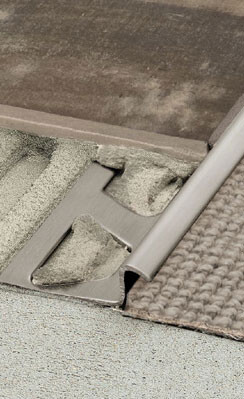 Close-up of a metal floor profile edge transition between carpet and tile.