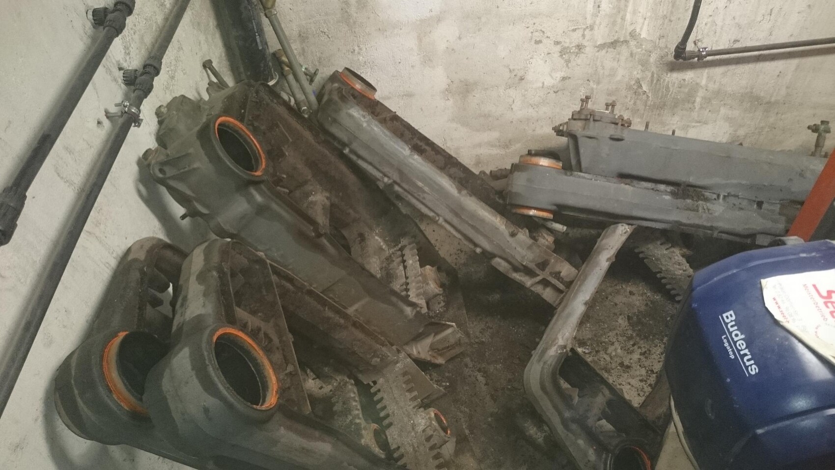 Basement room with dusty building systems, pipes, and machine parts.