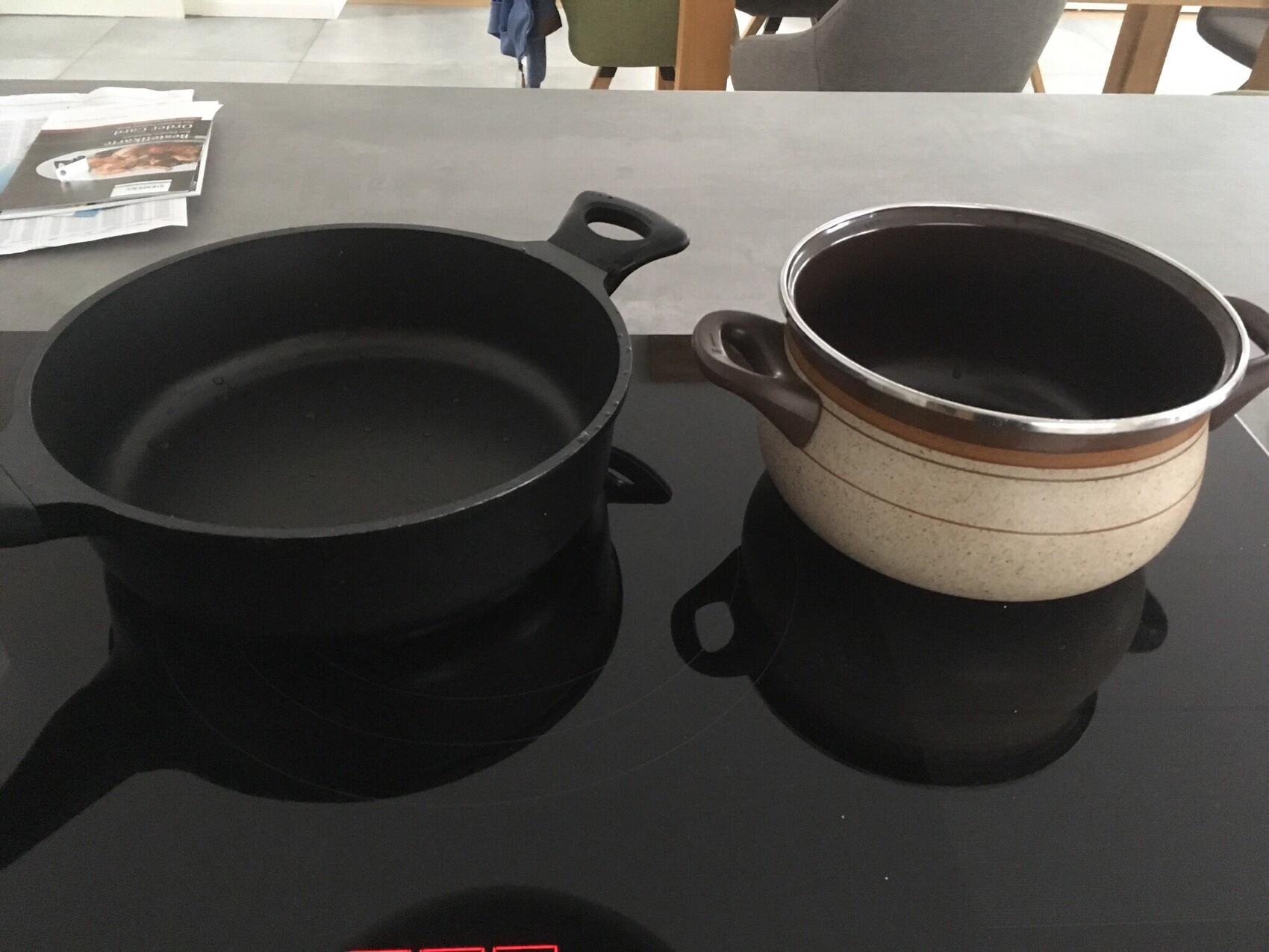 Two pots standing on an induction cooktop in a kitchen.