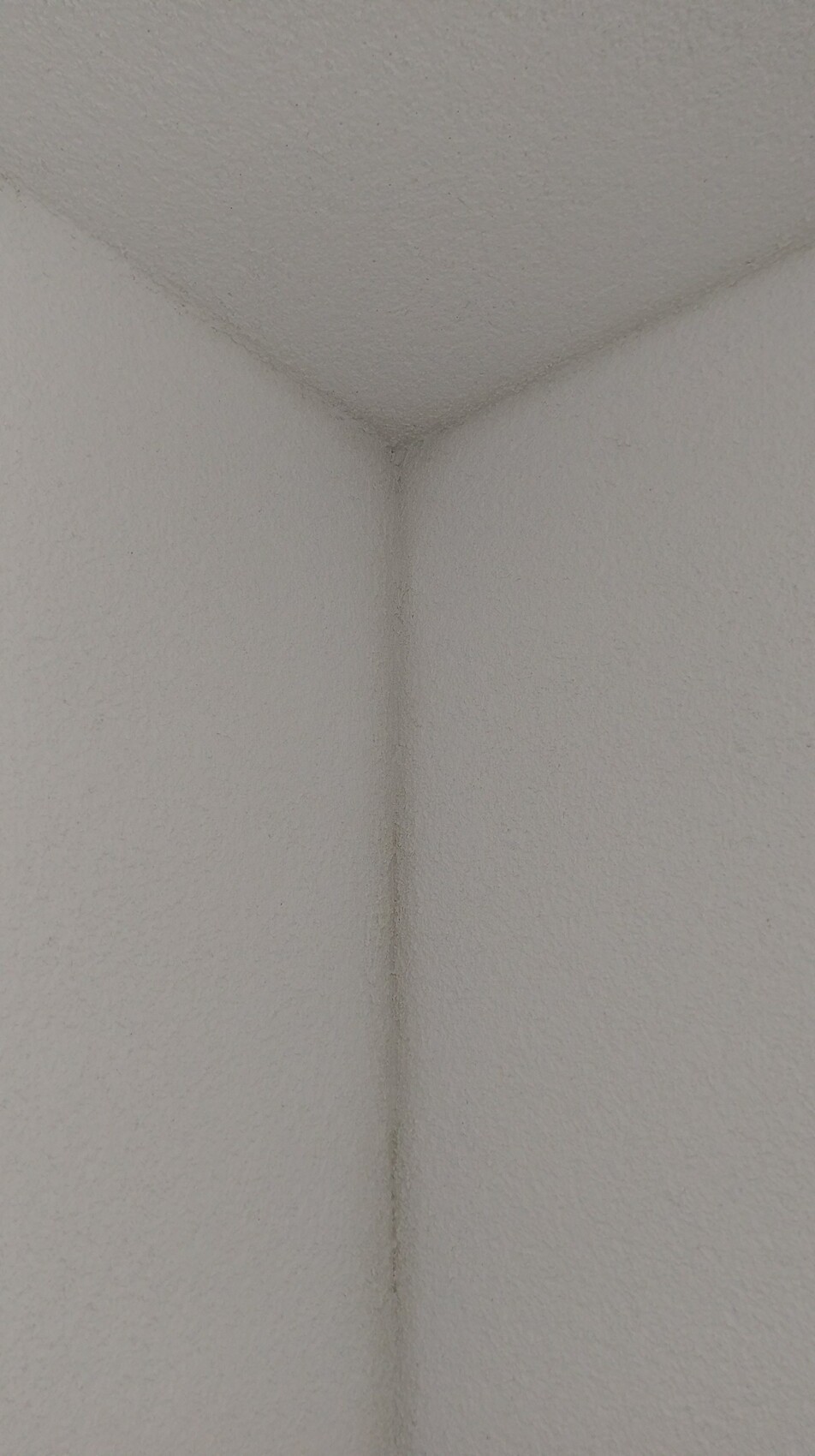 Close-up of a white textured interior wall corner inside the building