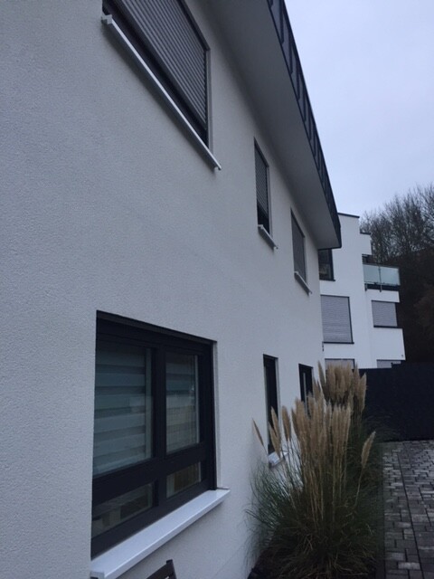 Exterior view of a modern white residential building with windows