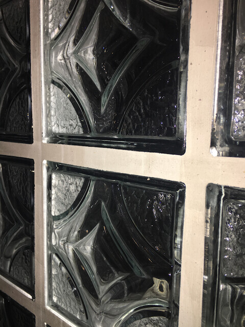 Close-up of glass blocks in a wall with joints and textured glass surface