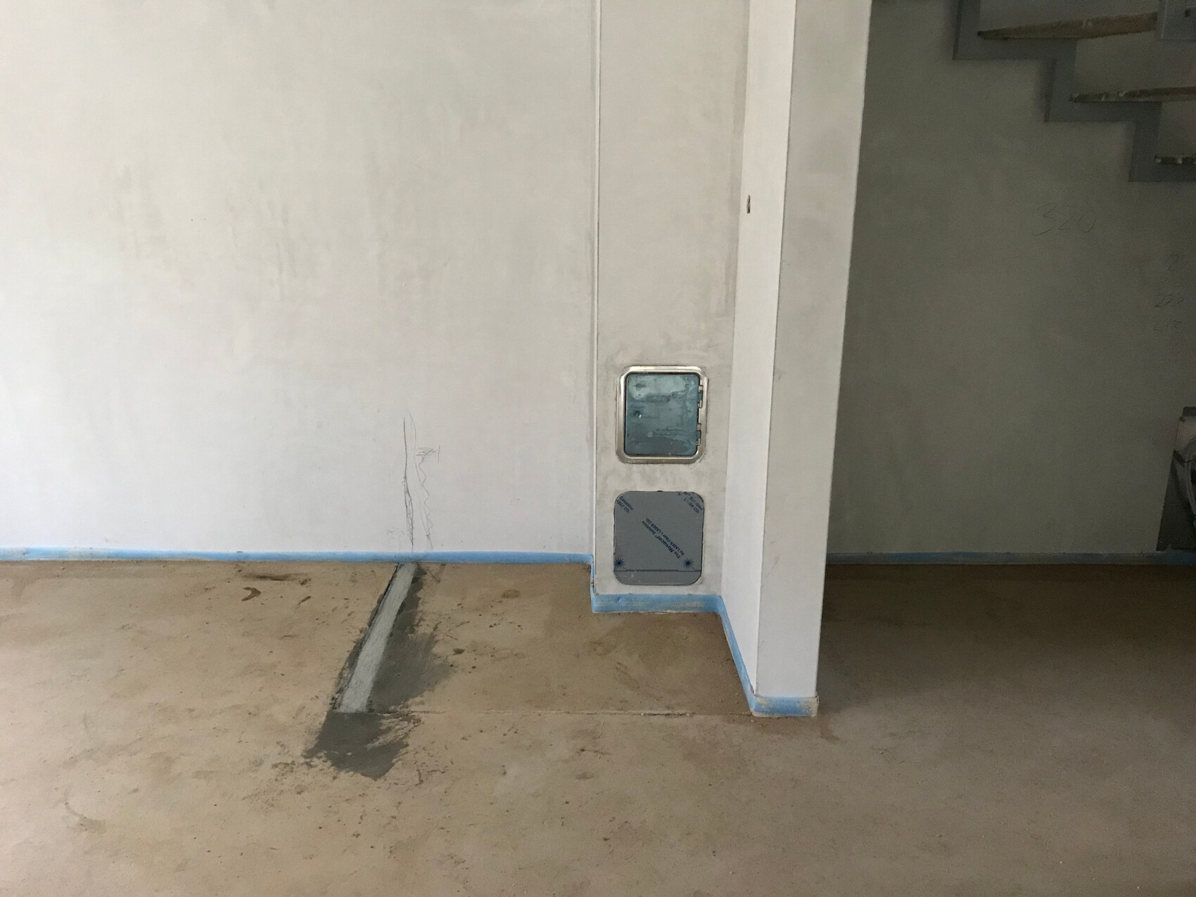 Unfinished interior with raw concrete floor, unpainted walls, and wall openings.