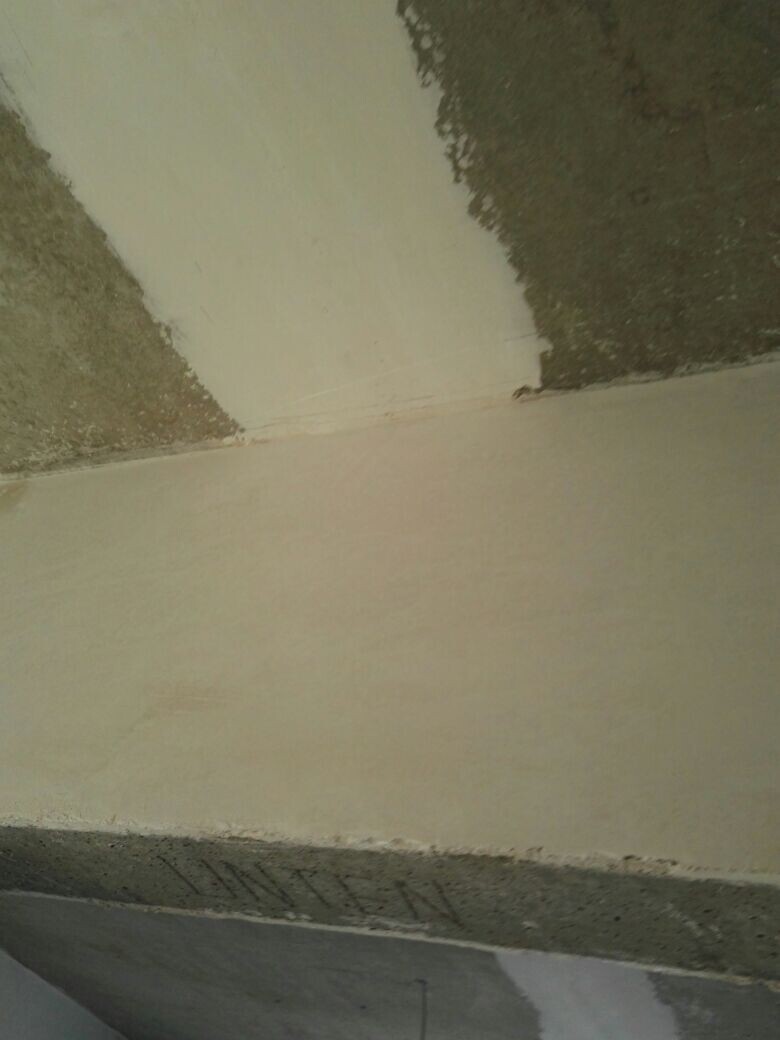 Construction site wall with plaster residues and exposed concrete in shell condition