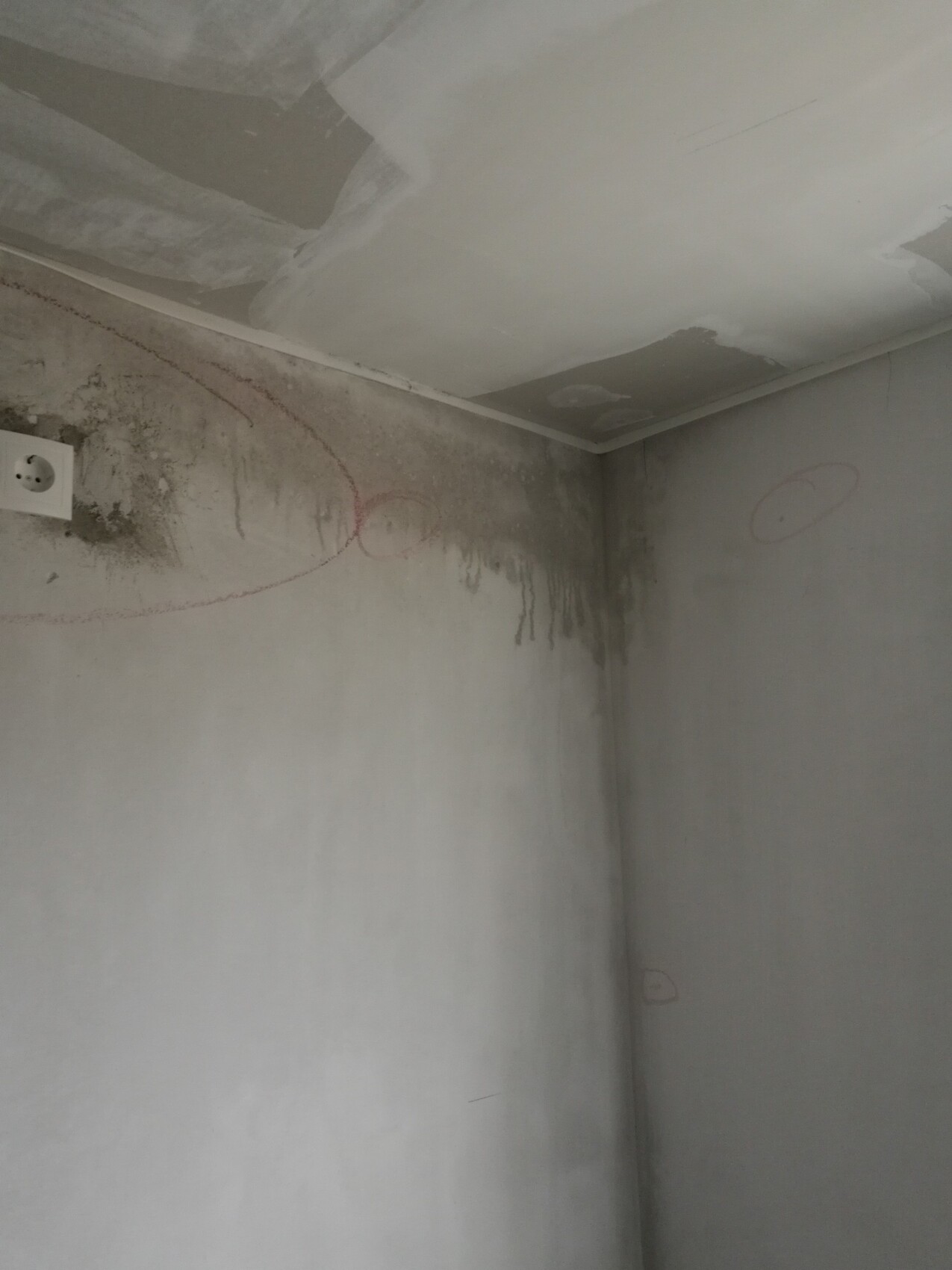 Feuchtigkeitsspuren in Innenraum-Ecke an Wand und Decke, Renovierungszustand.
