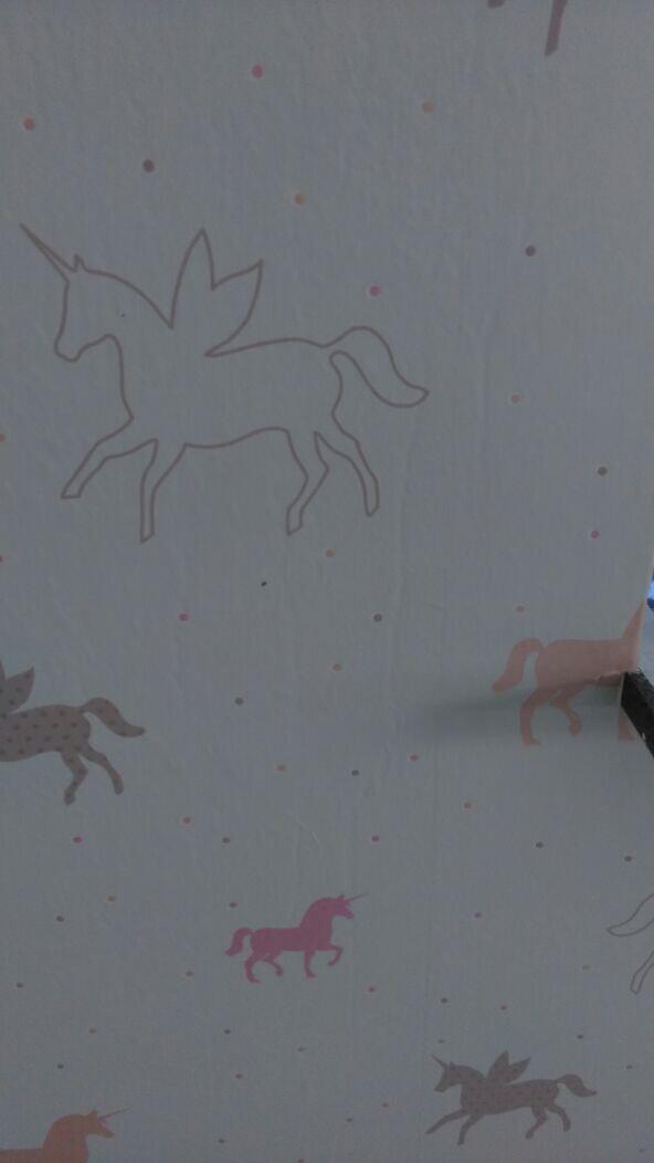 Wall with colorful unicorn designs as nursery decoration