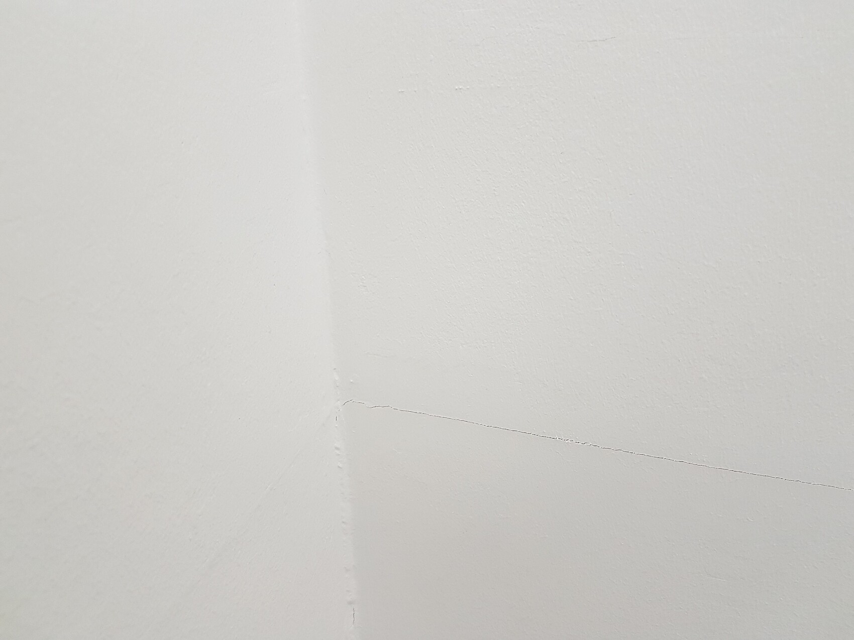 Angular white wall with visible crack in the corner area.